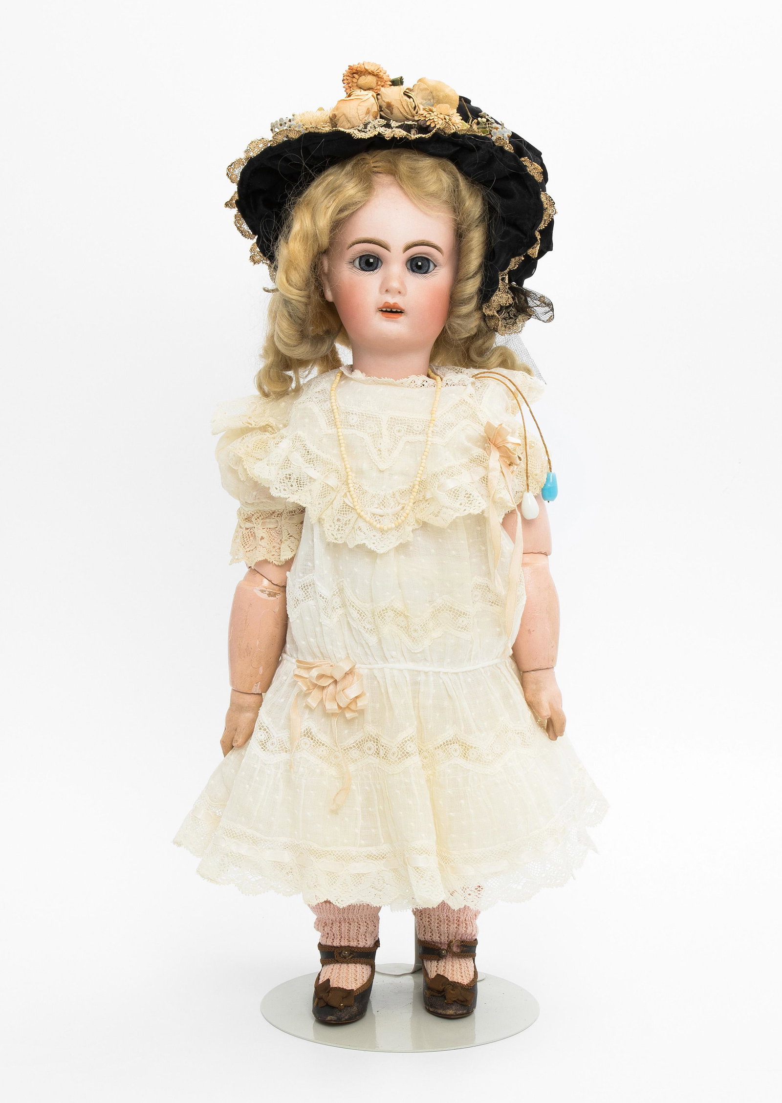 (Jumeau-)Puppe mit Mamastimme: Frankreich, um 1900. Unbezeichnet. Kurbelkopf mit Schlafaugen und offenem Mund aus Biscuit-Porzellan. Grössenangabe "7" und rotes Tintenzeichen "X". Gelenkkörper aus Masse (Gummizüge lose). Mit Zug