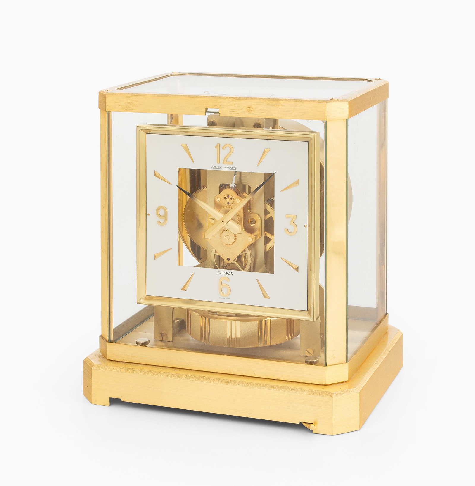 Atmos Jaeger-LeCoultre Nr.315081: Schweiz, 2.Hälfte 20.Jh. Allseitig mit Glas bestücktes, vergoldetes Messinggehäuse. Öffnungsknopf des Fronttürchens fehlt. Weisse, quadratische Zifferanzeige mit arabischer Viertelstundenanzeige 