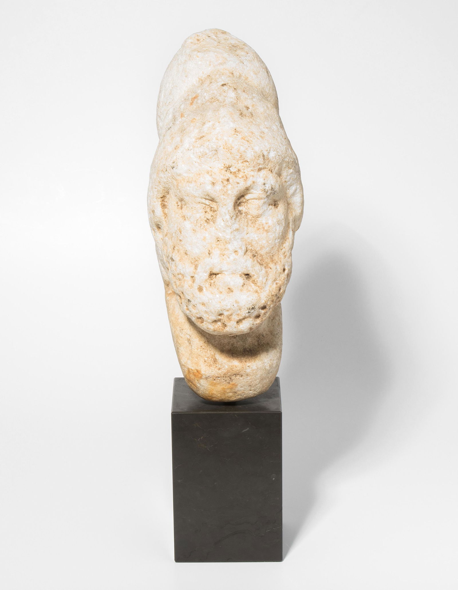 Kopf eines Feldherrn: Römisch, 2.Jh. n.C. Marmor. Männlicher Kopf mit Bart und emporgeschobenem, korinthischen Helm. An den Seiten kommt sein langes Haar unter dem Helm zum Vorschein. H 27,5 cm. - Nase und Teile des Helm