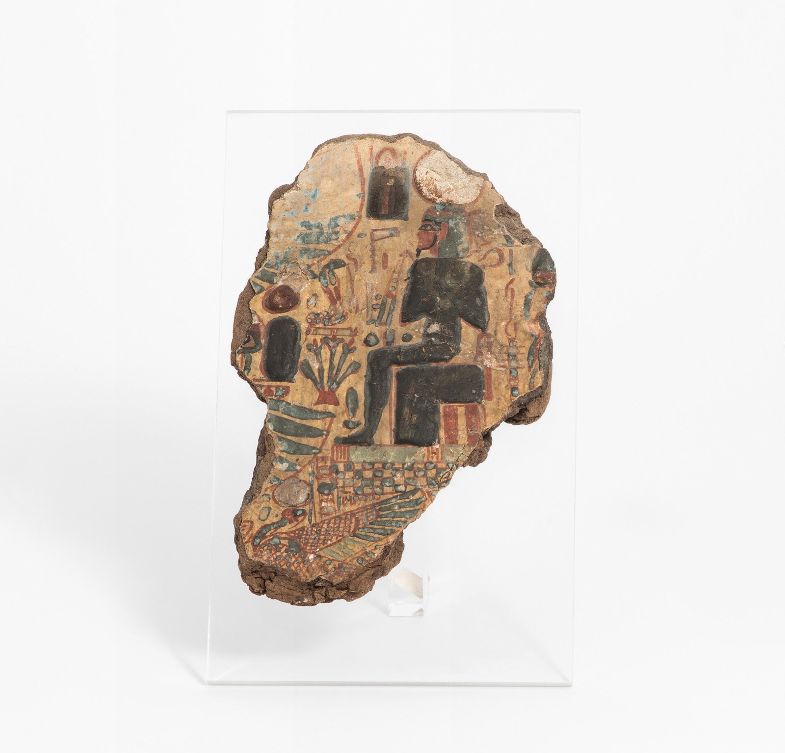 Fragment eines Holzsarkophagdeckels: Ägypten, Dritte Zwischenzeit, 21.Dynastie. Holz, stuckiert und polychrom bemalt. Ausschnitt mit Darstellung einer sitzenden Unterweltsgottheit, umgeben von zahlreichen Symbolen. H 13 cm.