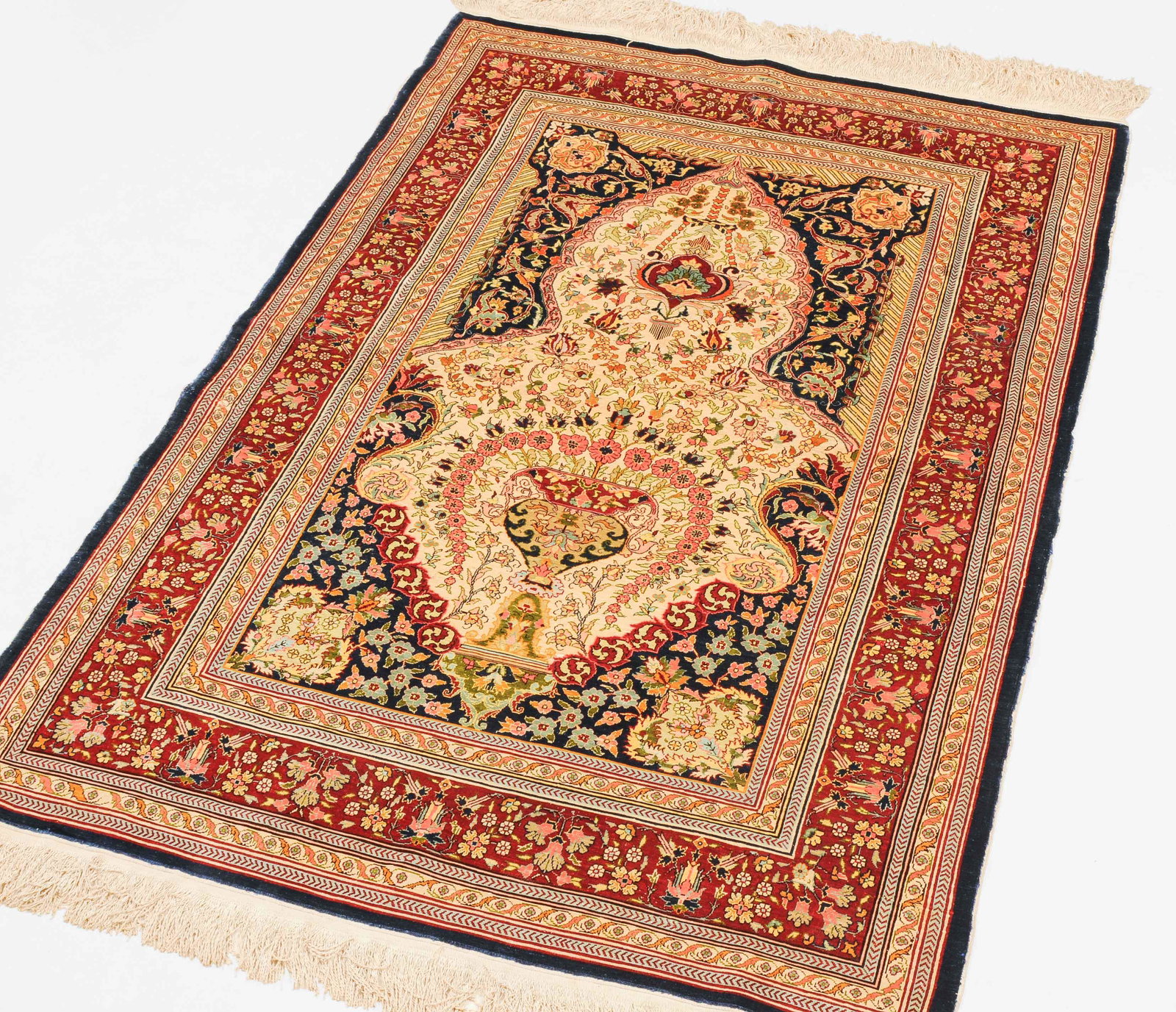 Hereke-Seide: N-Türkei, um 1980. Oben in der Mitte signiert mit "Hereke". Dichtes florales Werk. Unter einem mit Blattranken verzierten blauen Giebel liegt auf hellem Grund eine Gebetsnische (Mihrab), die mit eine
