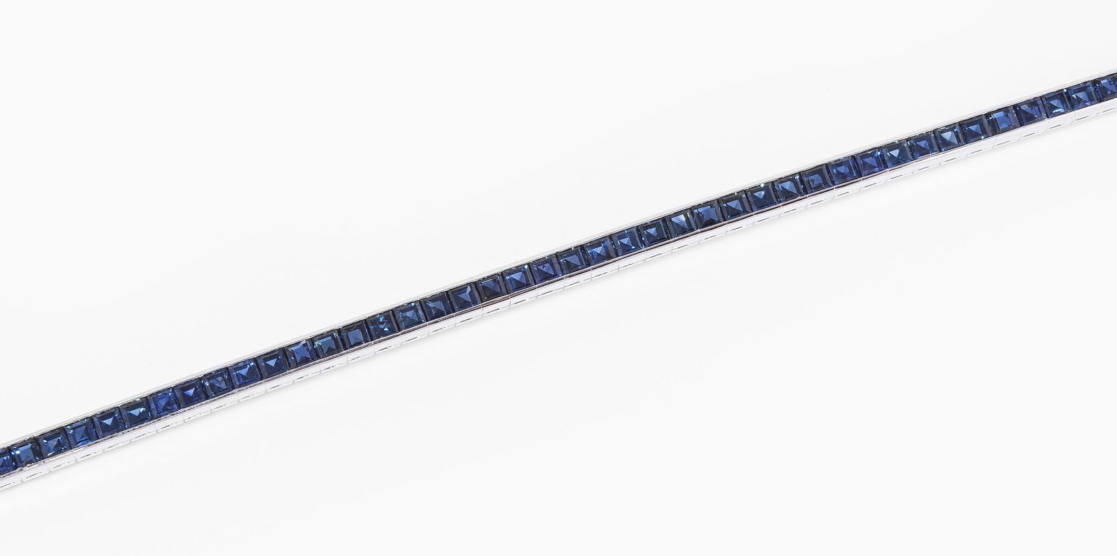 Saphir-Bracelet: Gübelin, Luzern. 1974. Rivière aus 55 Saphir-Carrés von 14.04 ct. L 18 cm, 23,7 g. Kopie Rechnung. Box.
