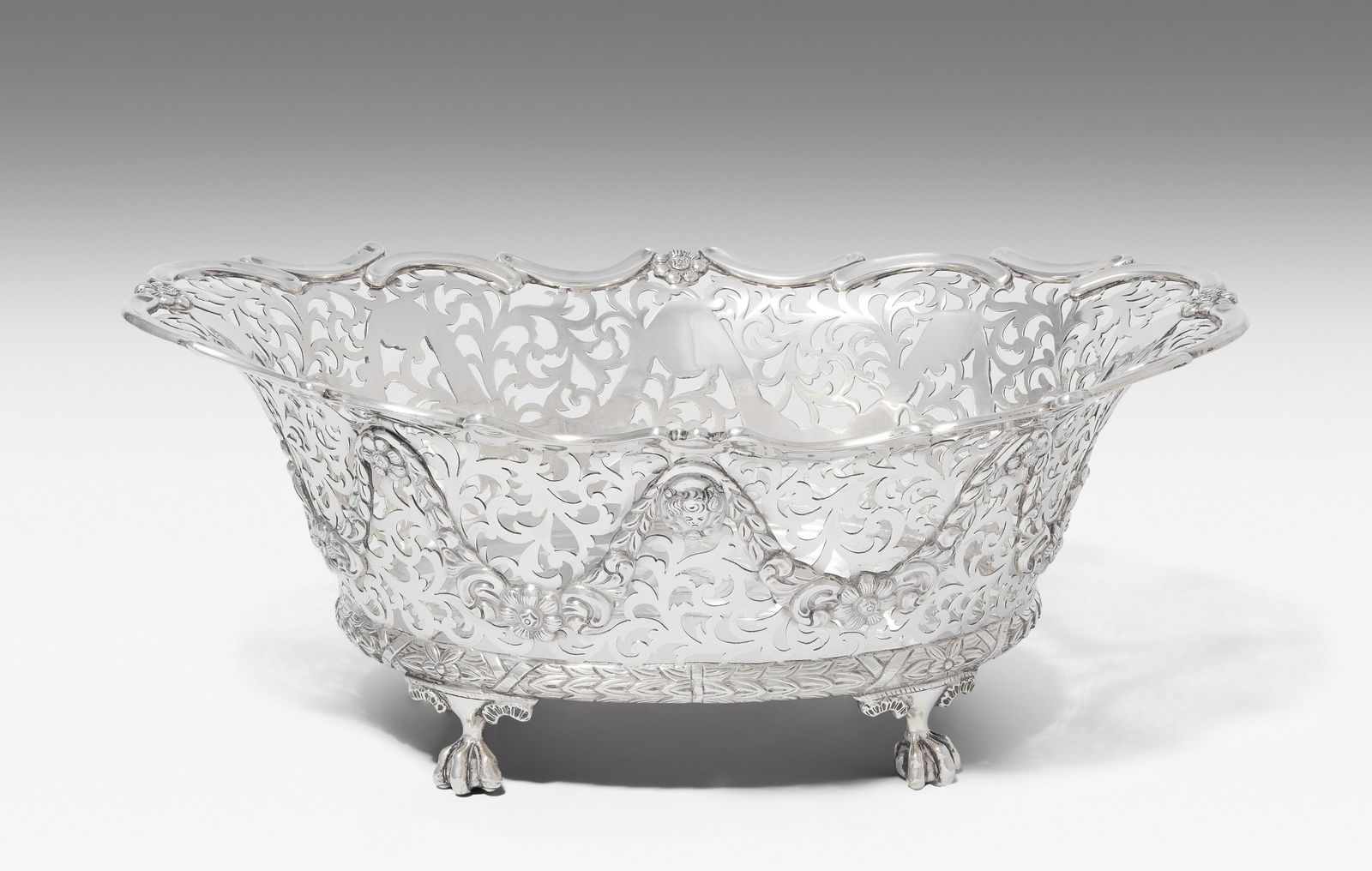 Korbschale: London, 1902. Silber. Meistermarke Charles Stuart Harris. Ovale Form auf Krallenfüssen, Wandung ornamental durchbrochen mit Girlandendekor und bewegtem Abschluss. Bodenunterseite mit gravierter Insch