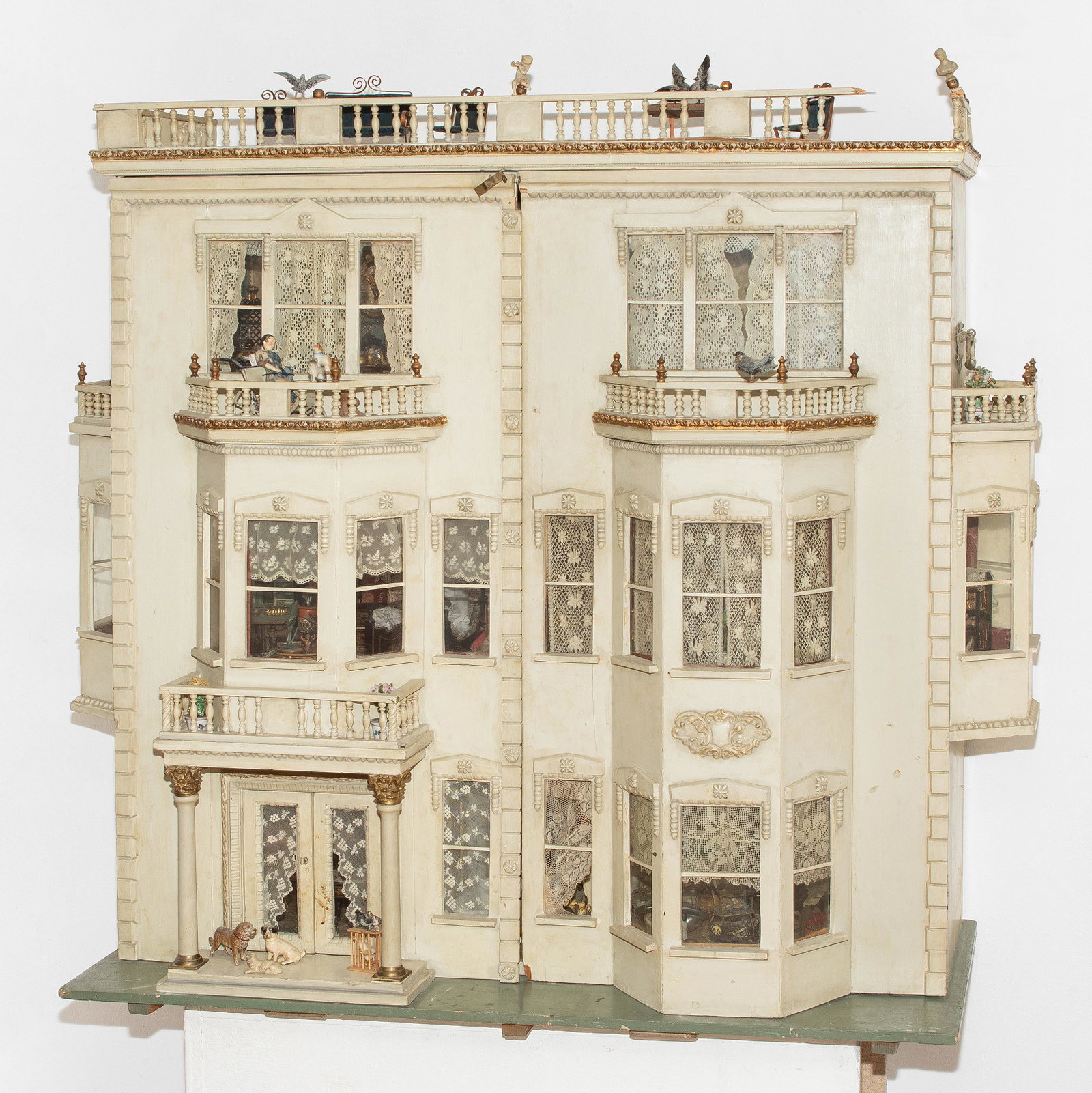 Grosses Puppenhaus: England, wohl Lines Brothers, um 1900, mit Ergänzungen. (1) Gehäuse. Dreistöckiges Haus mit Dachbalustrade und 2 seitlichen Erkern. Fronttüren mit Eingang und 3 Erkern. Aussen crèmeweiss bemalt, 