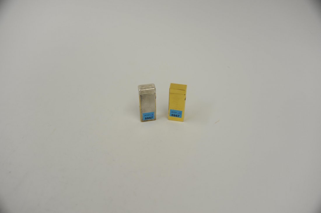 Dunhill, Lot: 2 Feuerzeuge Fein ziselierte Korpi. Das: Dunhill, Lot: 2 Feuerzeuge Fein ziselierte Korpi. Das eine aus Metall und Schriftzug "Peter Stuyvesant", das andere vergoldet. H 6,5/ 7 cm. Berieben. GehfÃ¤higkeit nicht Ã¼berprÃ¼ft.