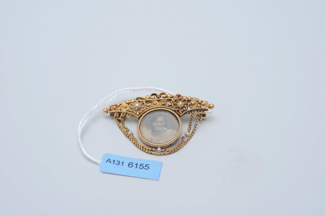 Filigran-Brosche 19. Jh. 750 Gelbgold.: Filigran-Brosche 19. Jh. 750 Gelbgold. Erinnerungsbrosche mit Portraitfoto, 1 Kulturperle (spÃ¤ter montiert) und 1 Imitationsperle von Ã˜ 2-2,5 mm, in Filigranarbeit Ã¼ber 2 Ankerketten mit 3 Na
