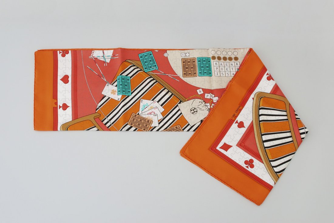 HermÃ¨s, Foulard "Faites vos Jeux" Seide. Spielmotive.: HermÃ¨s, Foulard "Faites vos Jeux" Seide. Spielmotive. Orange- und RottÃ¶ne. Ca. 90x90 cm. Guter Zustand.