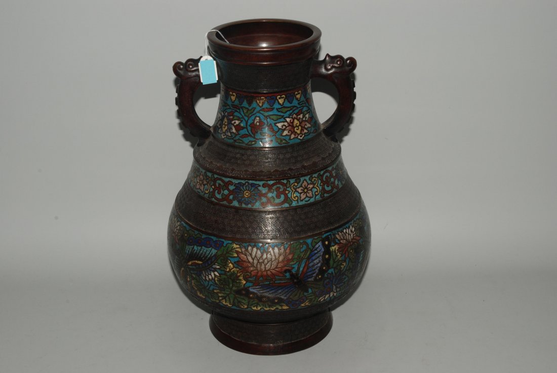 Henkelvase Japan, um 1900. Bronze mit Email champlevÃ©.: Henkelvase Japan, um 1900. Bronze mit Email champlevÃ©. Bauchige Form. Seitlich Makarakopfhenkel. Polychromer Blumen- und Schmetterlingdekor in Email champlevÃ©. Reliefiertes MÃ¤andermuster. H 3