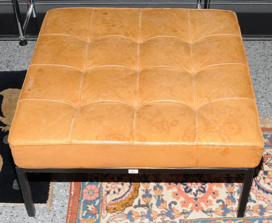 Knoll, Florence (1917) Hocker, 1954. Schwarz lackiertes: Knoll, Florence (1917) Hocker, 1954. Schwarz lackiertes Metallgestell mit Holzeinlage. Gepolstertes Sitzkissen mit braunem Lederbezug. Alters- und Gebrauchsspuren. 31x65x65 cm.