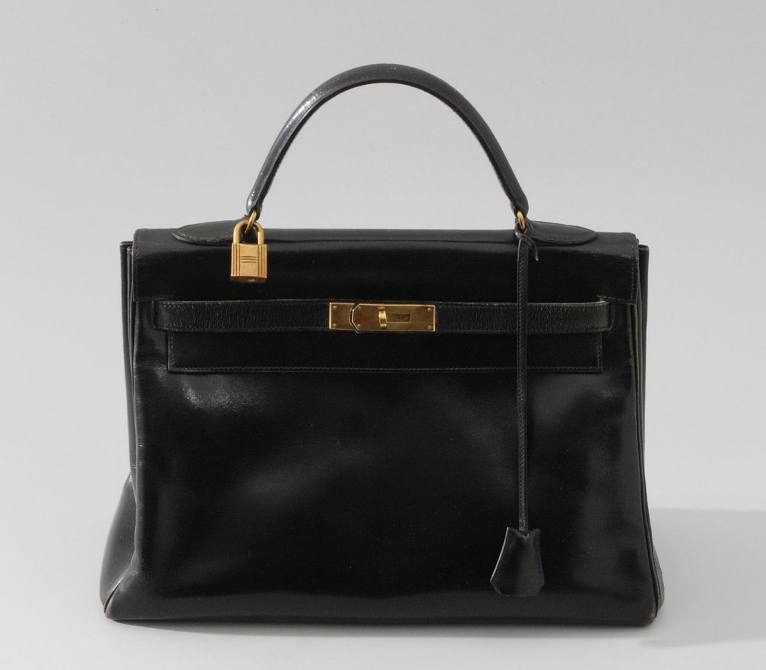 Hermès, Handtasche "Kelly", 32 cm Gemarkt "Hermès: Hermès, Handtasche "Kelly", 32 cm Gemarkt "Hermès Paris". Schwarzes Souple-Leder. Vergoldete Beschläge und klassisches Doppelzügelsystem. Hängeschloss sowie Clochette mit zwei Schlüsseln. Schutz