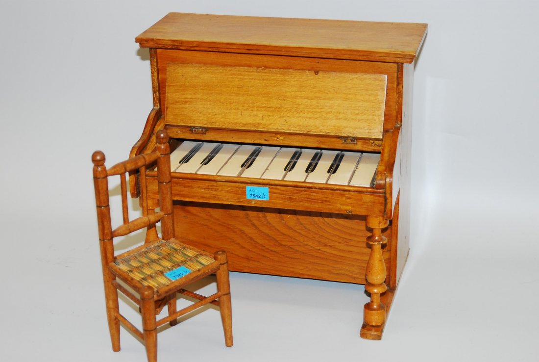 Puppen-Klavier 1.Hälfte 20.Jh. Holzgehäuse mit: Puppen-Klavier 1.Hälfte 20.Jh. Holzgehäuse mit gedrechselten Säulen, dazu geflochtener Stuhl. H 31 cm.