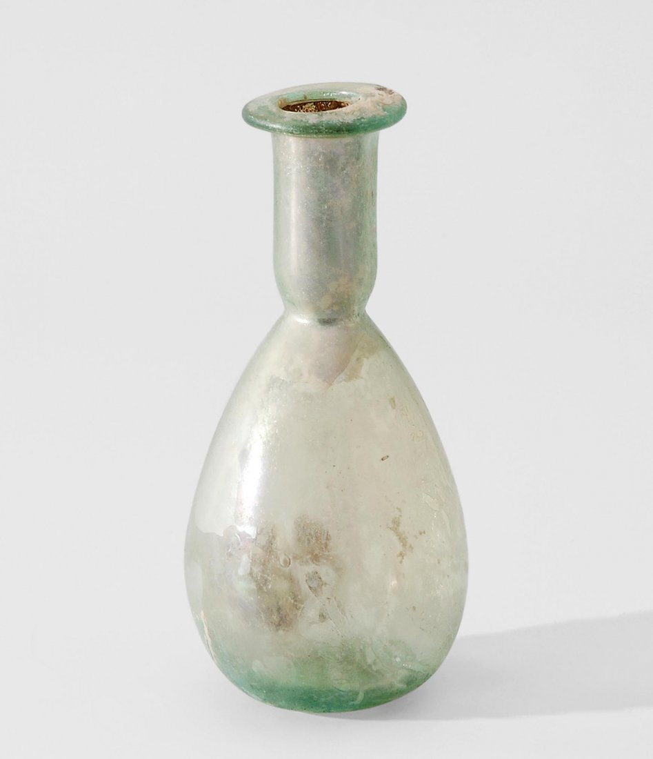 Kleine Flasche Östliches Mittelmeergebiet, 1.–3.Jh. n.: Kleine Flasche Östliches Mittelmeergebiet, 1.–3.Jh. n. Chr. Durchsichtiges, hellgrünes Glas, irisierend. Ovoider Corpus mit langem, zylindrischen Hals und breitem Rand. H 11.