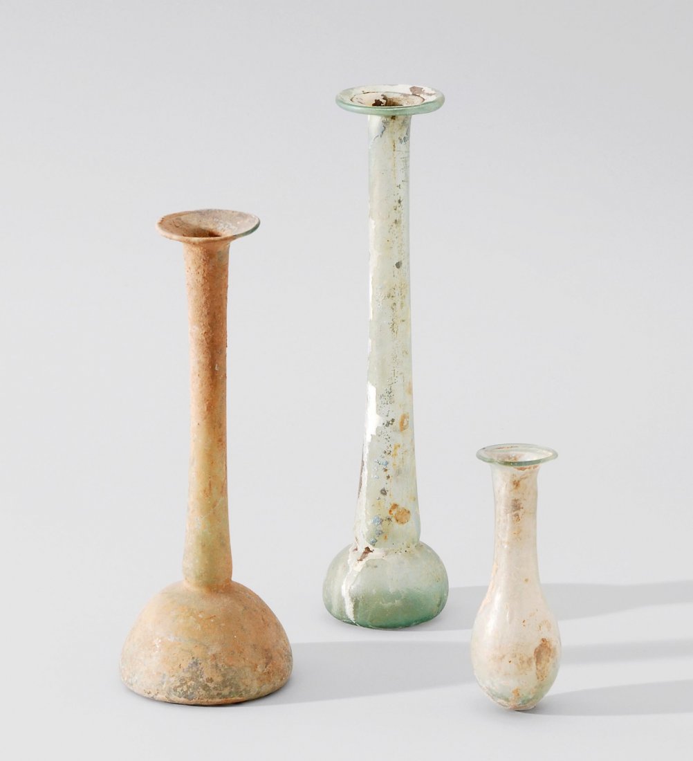 Lot: 2 Unguentari und 1 Balsamarium Östliches: Lot: 2 Unguentari und 1 Balsamarium Östliches Mittelmeergebiet, 1.–2.Jh. n. Chr. Durchsichtiges, bläulich-grünes Glas. Glockenförmig mit langem zylindrischen Hals und breitem Rand. H 16–19. Bi