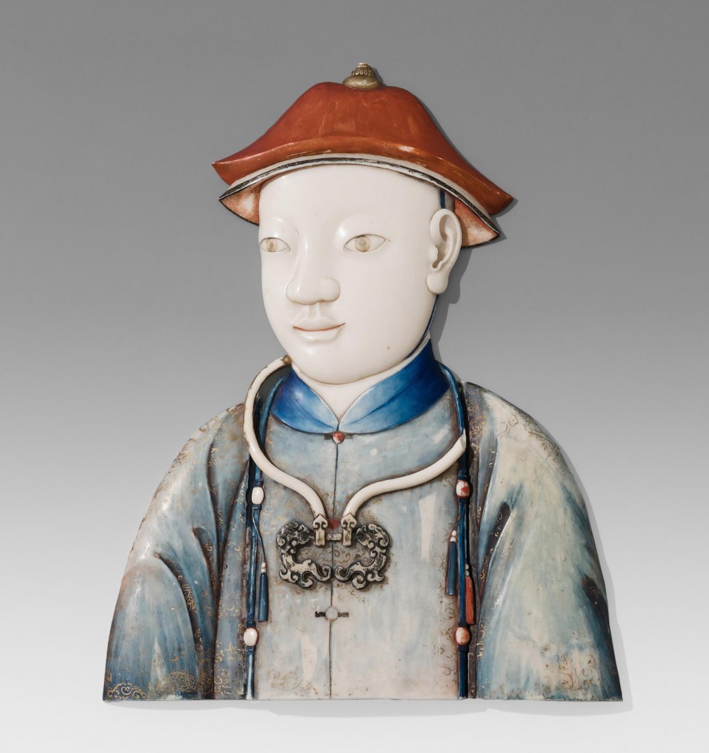 Relief China, um 1900. Elfenbein, geschnitzt und: Relief China, um 1900. Elfenbein, geschnitzt und bemalt. Leicht gewölbte, dreiteilige Plaketten. Halbportrait eines jungen Kaisers. Roter Hut und blaues Gewand sowie Pectoralschmuck tragend. Goldene 
