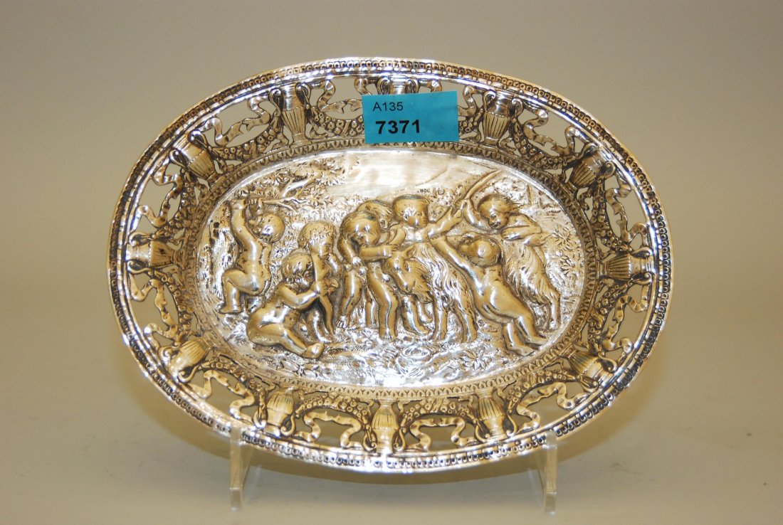 Kleines Korbschälchen Deutschland, um 1900. Silber.: Kleines Korbschälchen Deutschland, um 1900. Silber. Ovalform. Rand mit Vasen- und Girlandendekor durchbrochen, im Fond Puttidekor. 14x11x1,5 cm, ca. 90 g. Halbmond/Krone, Feingehalt 800.