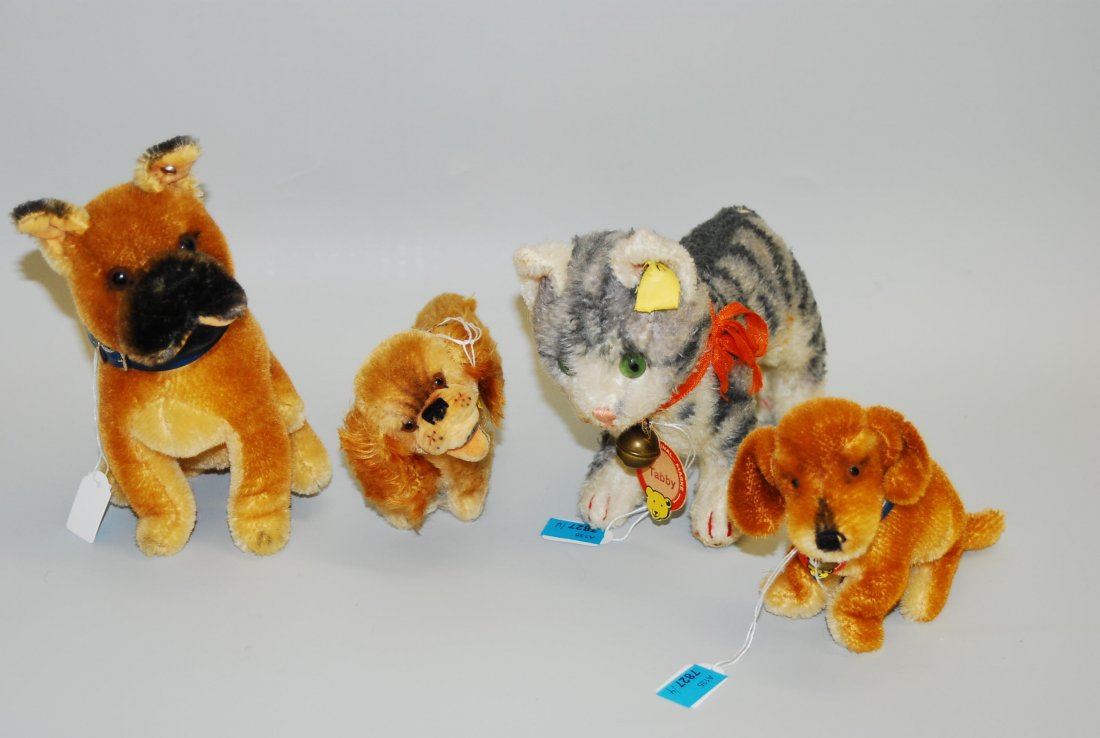 Lot: 4 Steiff-Tiere 1950/60er J. 3 Hunde und 1 Katze: Lot: 4 Steiff-Tiere 1950/60er J. 3 Hunde und 1 Katze aus Mohairplüsch: Cockie, Sarras, Bazi und Tabby. H 10–16 cm. - Tlw. stark bespielt.