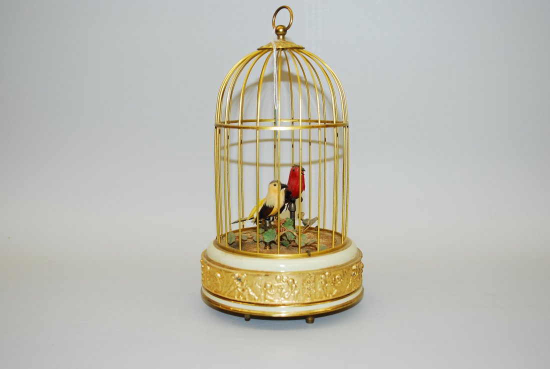Vogelautomat St. Croix, 20.Jh. Firma Reuge. Käfig aus: Vogelautomat St. Croix, 20.Jh. Firma Reuge. Käfig aus Messing mit integriertem Uhrwerk im Käfigboden. Zwei zwitschernde, sich bewegende Vöglein darin. H 29 cm.