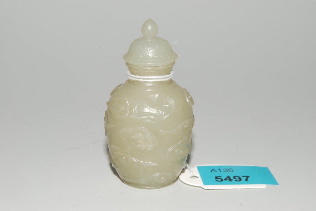 Snuffbottle China. Celadonfarbene Jade. Balusterform: Snuffbottle China. Celadonfarbene Jade. Balusterform mit reliefiertem Wolkendekor. Bombierter Stöpsel mit Knauf. Rand bestossen, Riss. H 5,5 cm.