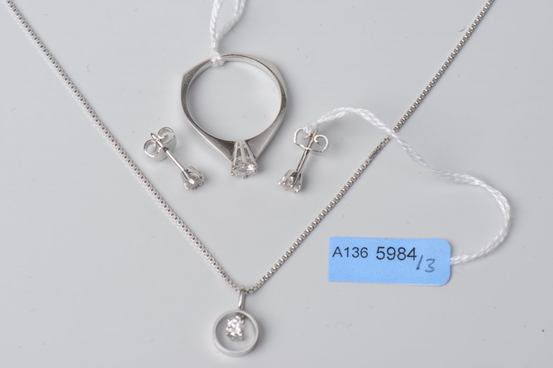 Set: Ring, Ohrstecker, Collier 750 Weissgold. Ring:: Set: Ring, Ohrstecker, Collier 750 Weissgold. Ring: Solitaire, 1 Brilliant ca. 0.25 ct. Gr. 53. Ohrstecker: 2 Brillanten ca. 0.20 ct. Kette: Venezianer Kettchen, Anhänger mit 1 Brillanten ca. 0.12 ct