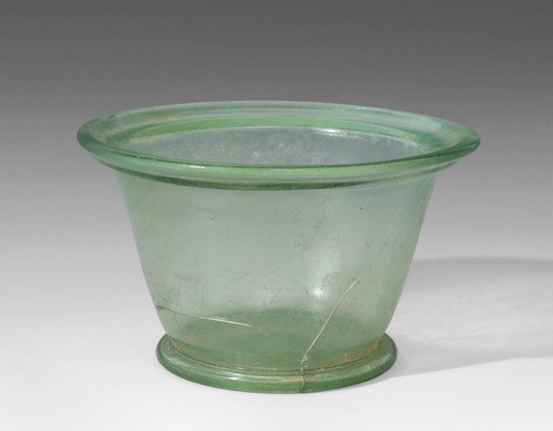 Schale Östlicher Mittelmeerraum, ca. 3.Jh. n. Chr.: Schale Östlicher Mittelmeerraum, ca. 3.Jh. n. Chr. Grünliches Glas, dickwandig. Konisch auf (vermutlich angesetztem) Standring, weit ausladender Rand mit Wulst. Leicht verwittert. Riss, Kratzer auf 