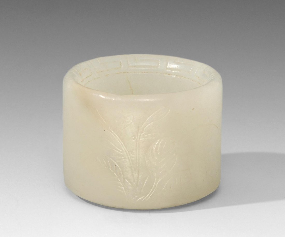 Bogenschützenring China. Weisse Jade. Gravierter: Bogenschützenring China. Weisse Jade. Gravierter Pflanzendekor. Beide Ränder graviert mit Mäandermotive. Haarriss. H 2, D 2,5 cm.
