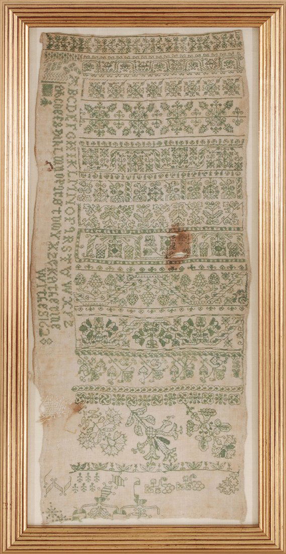 Stickmustertuch (Sampler) England, datiert 1628. Grünes: Stickmustertuch (Sampler) England, datiert 1628. Grünes Garn auf hellem Stoff. Feine florale Zierbänder sowie Buchstabenreihe und Datum. 43,5x19 cm. Gerahmt. - Leicht stockfleckig. Kleine Schad- und