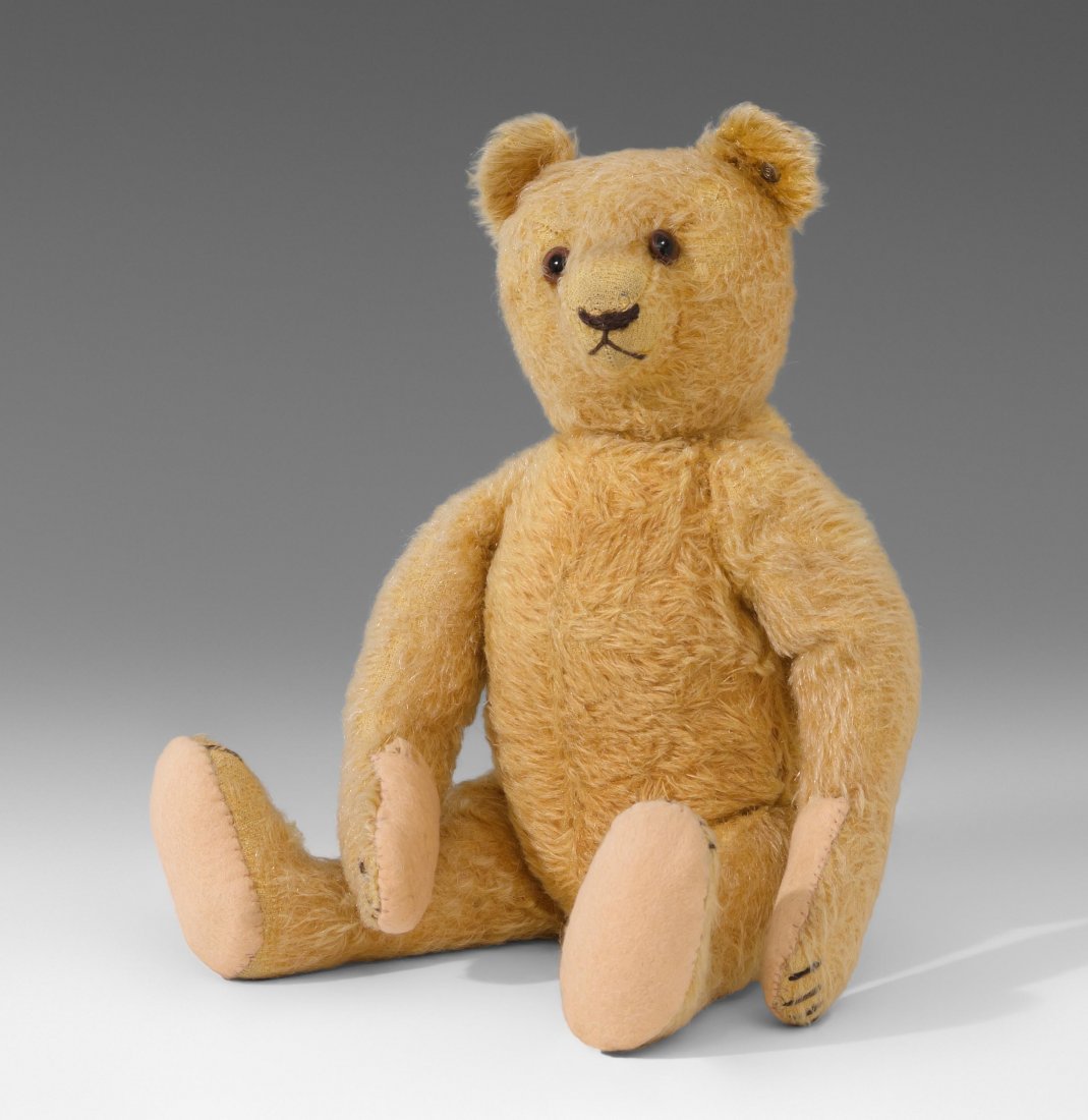 Steiff-Teddybär Deutschland, 1930er/40er Jahre.: Steiff-Teddybär Deutschland, 1930er/40er Jahre. Gegliederter Körper aus blondem Mohairplüsch. Nase, Mund und Krallen gestickt. Sohlen aus Filz. Braune Glasaugen. Mit Knopf. H 30 cm. - Leicht abgeli