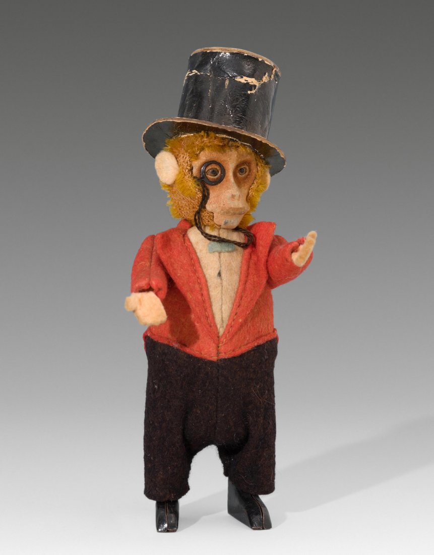 Frühe Schuco-Tanzfigur "Affe als Kavalier" Deutschland,: Frühe Schuco-Tanzfigur "Affe als Kavalier" Deutschland, um 1930. Metallkörper mit Plüschkopf und bunter Filzbekleidung. Affe als Kavalier mit Zylinder und Monokel. Mit Uhrwerk. Ohne Schlüssel. H 1