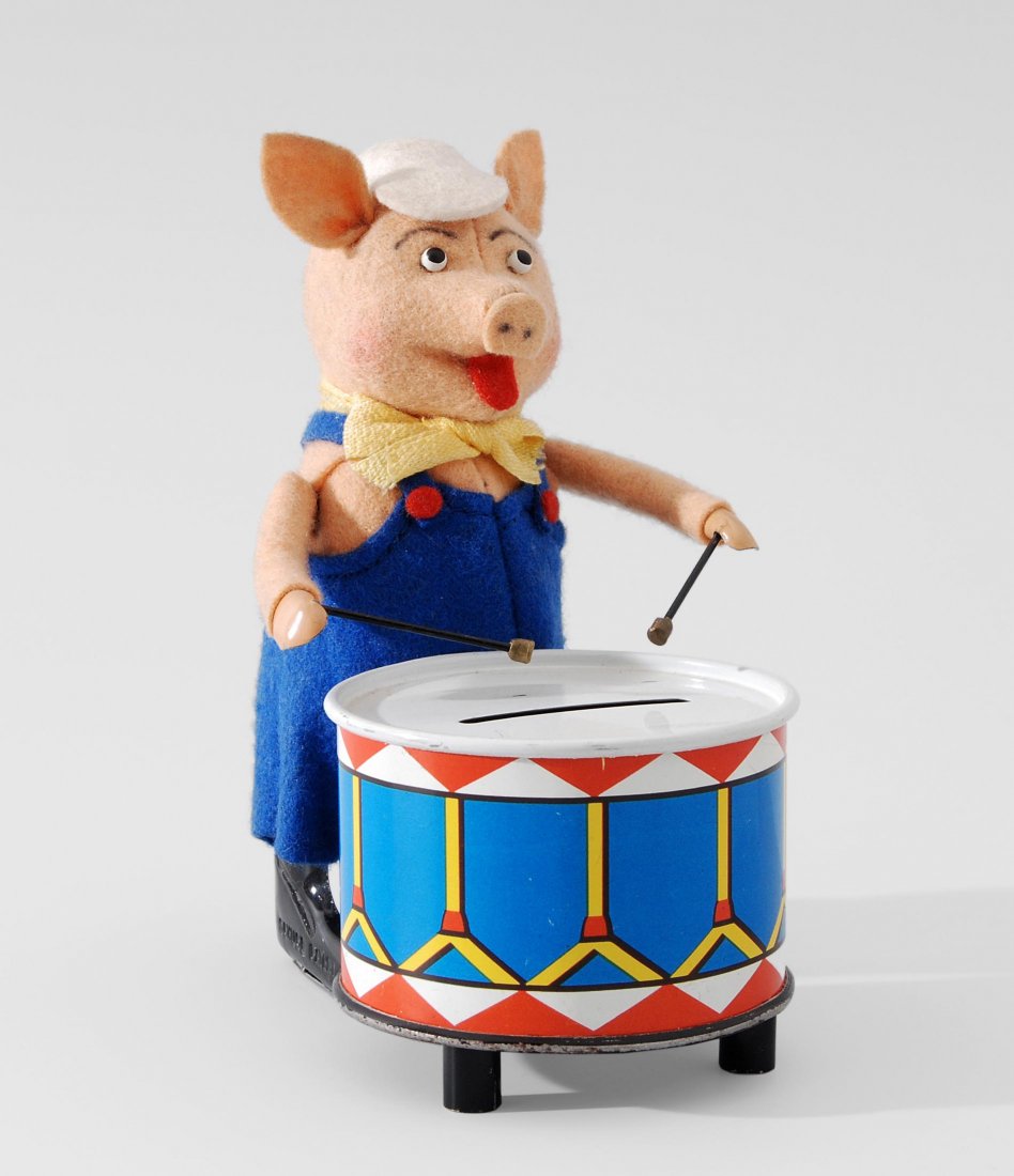 Schuco-Tanzfigur "Schweinchen als Trommler": Schuco-Tanzfigur "Schweinchen als Trommler" Deutschland, 1950er/60er Jahre. Metallkörper mit rosa Filzbezug und bunter Filzbekleidung. Walt Disney-Schweinchen mit vergrösserter Trommel als Spardose.