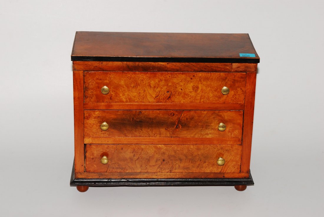 Kleine Modellkommode Biedermeier. Wurzelfurnier.: Kleine Modellkommode Biedermeier. Wurzelfurnier. Beschläge aus Messing. Rechteckiger, 3-schübiger Korpus auf 4 Füsschen. 31x14x25 cm.