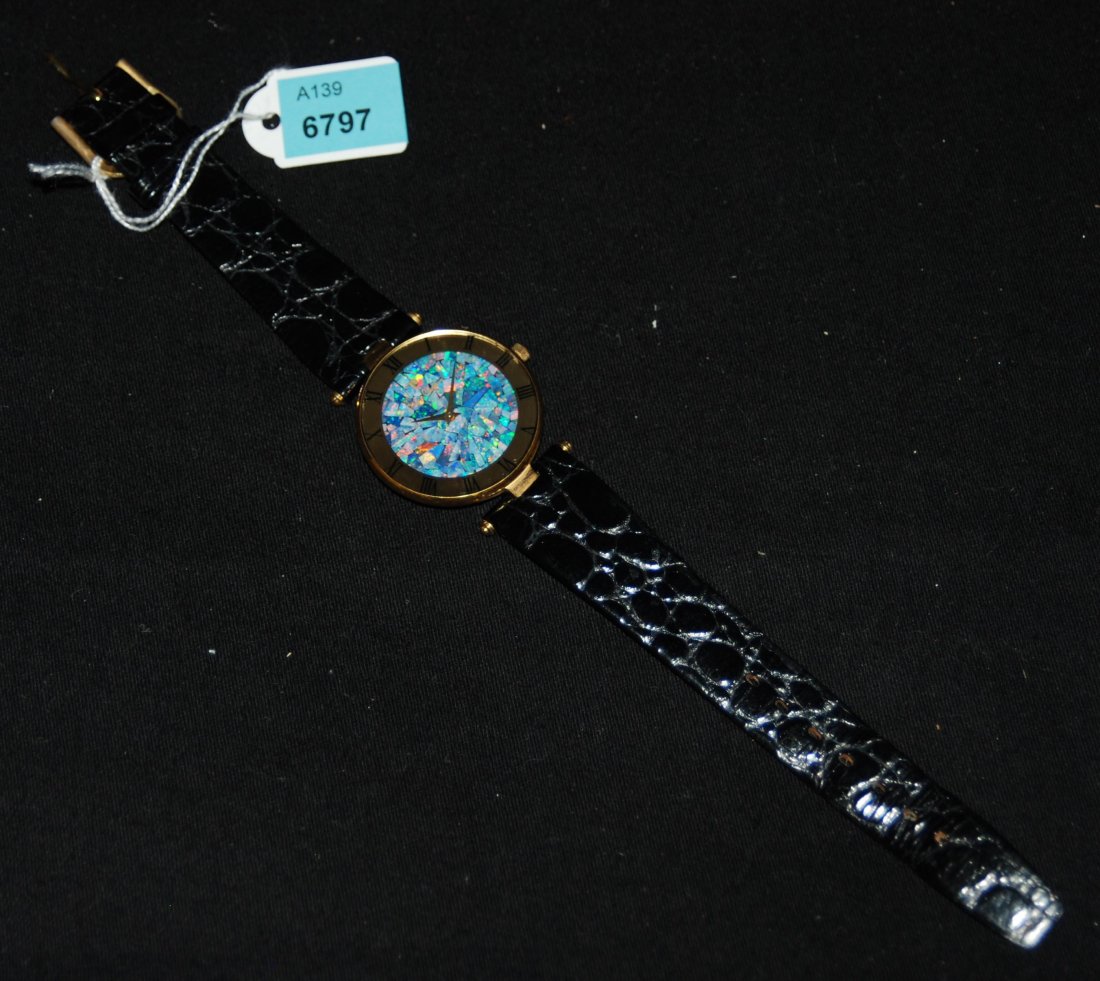 Pierre Cardin, Armbanduhr Runde Armbanduhr mit: Pierre Cardin, Armbanduhr Runde Armbanduhr mit Quarzwerk. Goldfarbenes Gehäuse mit römischen Stundenzahlen. Zifferblatt mit irisierendem Mosaik-Dekor. Schwarzes Armband in Kroko-Imitation. D 3 cm. B