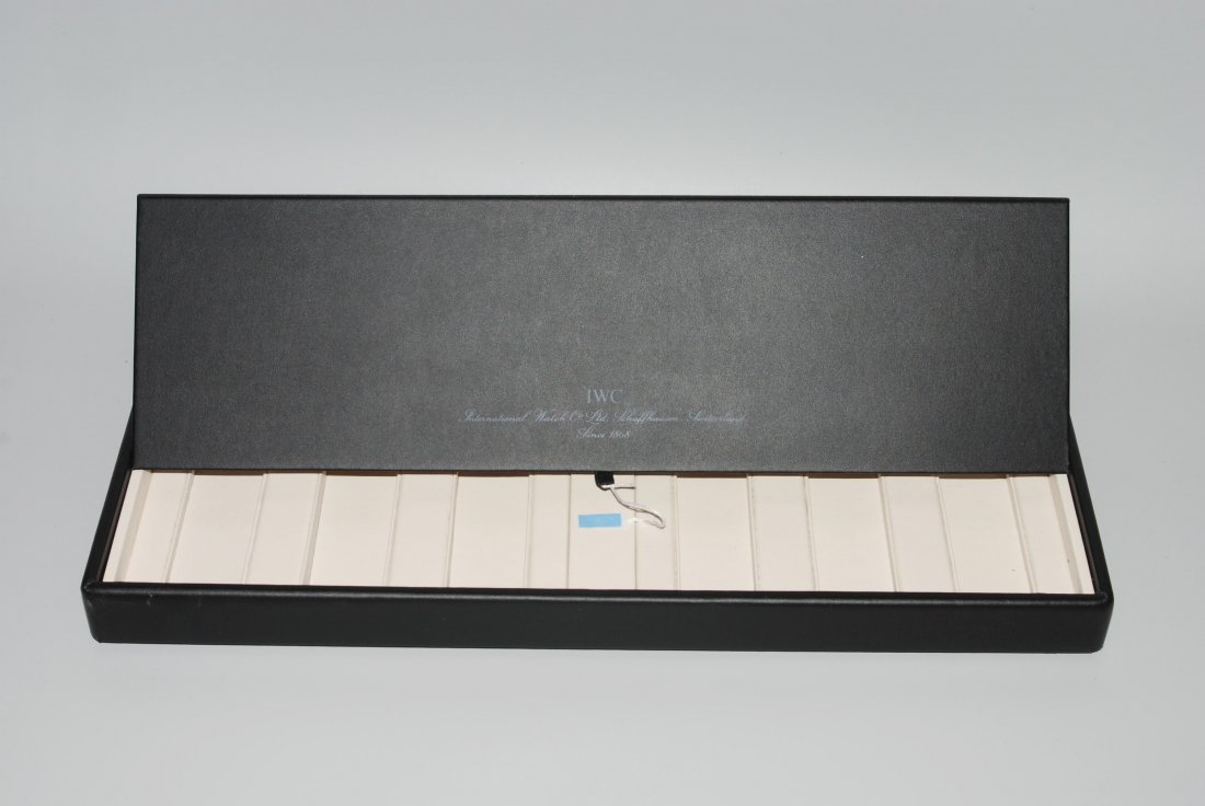 IWC Präsentationsbox Schwarze Präsentationsbox in: IWC Präsentationsbox Schwarze Präsentationsbox in Lederoptik mit IWC Prägung innen und aussen für 6 Armbanduhren 44x27x3 cm. Faltdeckel mit Lasche. Gebrauchsspuren.