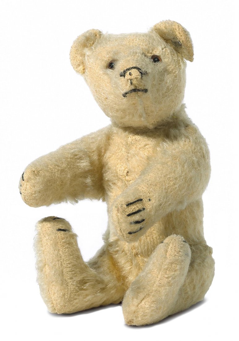 Kleiner Steiff-Teddybr Deutschland, um 1930/40.: Kleiner Steiff-Teddybr Deutschland, um 1930/40. Gegliederter Krper aus blondem Mohairplsch. Nase, Mund und Krallen gestickt. Braune Glasaugen. Mit Knopf. H 18 cm. - Abgeliebt. Kleine Schad- und Fehlst