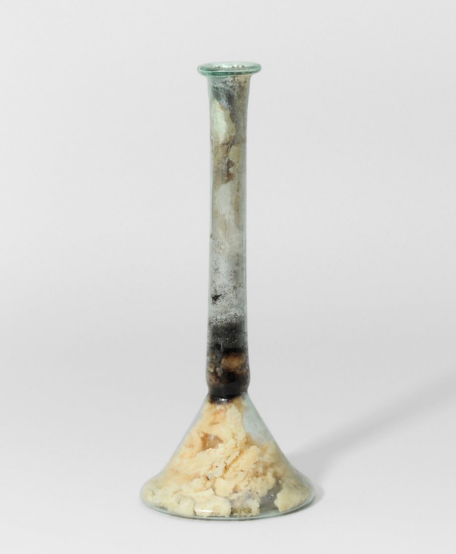 *Unguentarium Östlicher Mittelmeerraum, 1.–2.Jh. n.: *Unguentarium Östlicher Mittelmeerraum, 1.–2.Jh. n. Chr. Durchscheinendes, leicht bläulich-grünes Glas. Konischer Corpus mit leicht konkavem Boden. Hoher, zylindrischer Hals. Innen mit Resten ein
