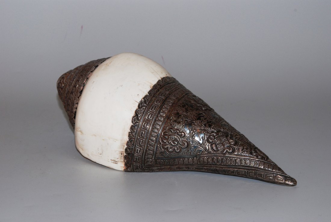 Muschelhorn (Shanka) Nepal. Rechtsdrehende Muschel mit: Muschelhorn (Shanka) Nepal. Rechtsdrehende Muschel mit getriebener und gravierter Silbermontur. L 26,5 cm.