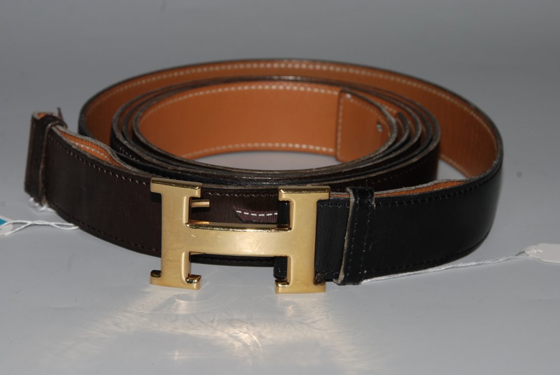 Hermès, zwei Ledergürtel Eine H-Schliesse aus: Hermès, zwei Ledergürtel Eine H-Schliesse aus goldfarbenem Metall, ein schwarzer und ein dunkelbrauner Lederriemen. Schliesse wechselbar. Gr. 97 cm. Gebrauchsspuren. Schliesse mit Kratzer.