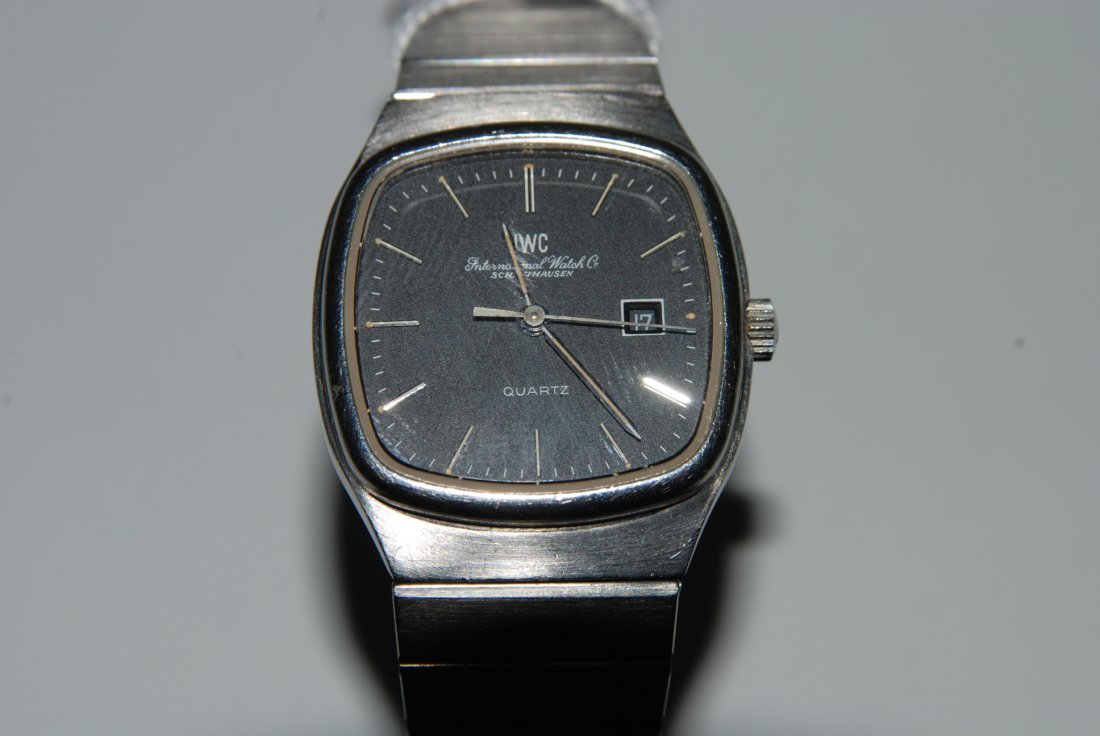 IWC Quadratische Damenarmbanduhr 70er Jahre mit: IWC Quadratische Damenarmbanduhr 70er Jahre mit Quarzwerk in Stahlgehäuse. Boden verschraubt, Gehäusenummer 2257228, 26x26 mm. Schwarzes Zifferblatt mit aufgesetzten, silberfarbenen Stundenindizes, 