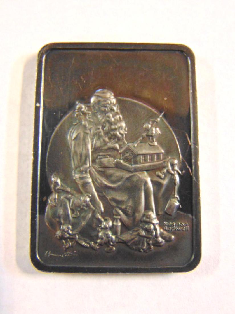 1975 NORMAN ROCKWELL SILVER SANTA CHRISTMAS INGOT: A COLLECTIBLE 1975 NORMAN ROCKWELL CHRISTMAS INGOT ENTITLED " SLUMBERING SANTA". INGOT WEIGHS 32.9g AND IS MADE OF .999 OF FINE FINE SILVER. CONDITION LOOKS GOOD FOR ITS AGE BUT DOES HAVE SOME WEAR OR
