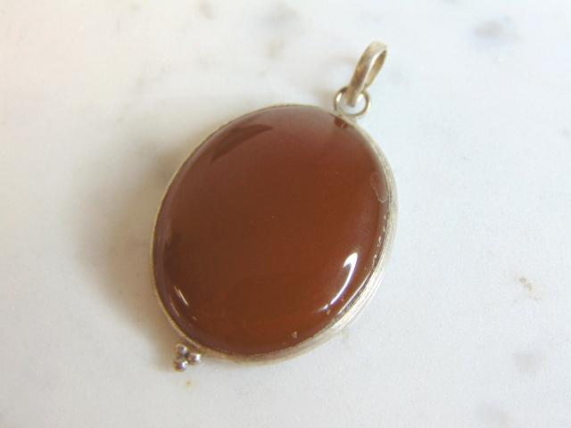 Womens Vintage Estate Sterling Silver Carnelian Pendant: FOR SALE IS THIS WOMENS VINTAGE ESTATE STERLING SILVER CARNELIAN COLORED PENDANT . NOT SURE IF STONE IS REAL OR MAN MADE. PENDANT WEIGHS 7.8g AND PENDANT MEASURES 1 5/8" LONG BY 1" WIDE. MAKES A GREAT