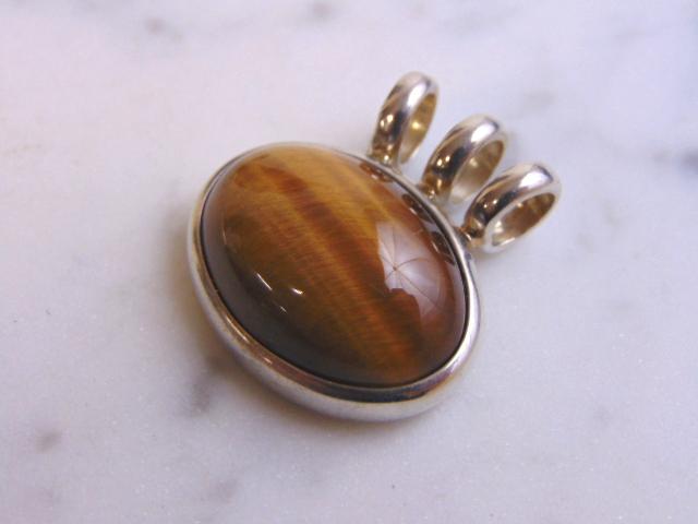 Womens Vintage Sterling Silver Tigers Eye ESPO Pendant: A VINTAGE ESTATE WOMENS .925 STERLING SILVER ESPO PENDANT WITH WHAT APPEARS TO BE A TIGERS EYE STONE. THE PENDANT MEASURES 1" LONG BY 1" WIDE, AND WEIGHS 11.7g. THIS WOULD MAKE A LOVELY GIFT FOR THAT 
