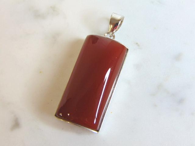 Womens Vintage Estate Sterling Silver Carnelian Pendant: FOR SALE IS THIS WOMENS VINTAGE ESTATE STERLING SILVER CARNELIAN COLORED PENDANT . NOT SURE IF STONE IS REAL OR MAN MADE. PENDANT WEIGHS 10.2g AND PENDANT MEASURES 1 5/8" LONG BY 5/8" WIDE. MAKES A GR