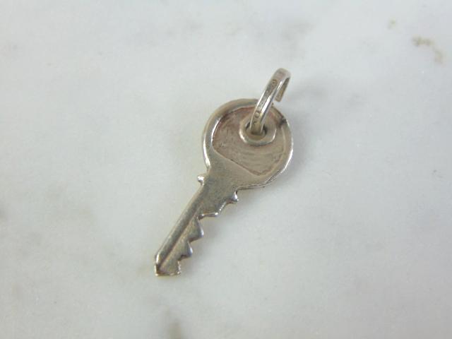 Womens Vintage Estate Sterling Silver Key Charm: FOR SALE IS THIS WOMENS VINTAGE ESTATE STERLING SILVER KEY CHARM. CHARM WEIGHS 1g AND MEASURES 7/8" LONG BY 3/8" WIDE. MAKES A GREAT GIFT FOR THAT SOMEONE SPECIAL. IF ANY QUESTIONS, PLEASE ASK. BE SUR