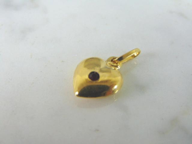 Womens Vintage Estate 14k Yellow Gold Heart Charm: A WOMENS VINTAGE ESTATE 14K YELLOW GOLD HEART PENDANT OR CHARM WITH A TINY GARNET LIKE STONE IN THE CENTER. PIECE WEIGHS 1.1g, AND MEASURES 5/8" LONG BY 3/8" WIDE. MAKES A GREAT GIFT FOR THAT SOMEONE 
