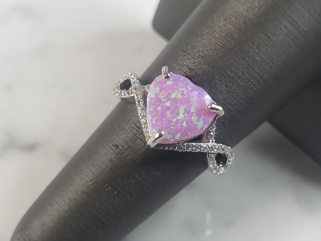 Womens Vintage Estate Sterling Silver Pink Opal Stone Ring: A WOMENS ESTATE STERLING SILVER PINK OPAL STONE RING. NOT SURE IF STONES ARE REAL OR MAN MADE. THE RING WEIGHS 3.1g AND IS A SIZE 6.5 FACE MEASURES 3/8". MAKES A GREAT GIFT FOR THAT SOMEONE SPECIAL. I