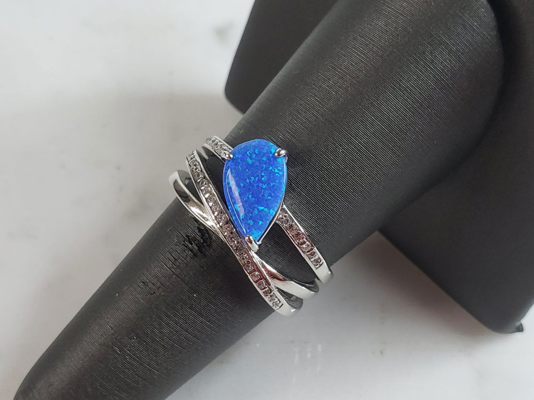 Womens Estate Sterling Silver Modernist Blue Opal Ring: A WOMENS ESTATE STERLING SILVER MODERNIST OPAL COLORED RING. THE RING IS A SIZE 7.0 AND WEIGHS 4.3g. WIDTH OF THE RING MEASURES 1/2". NOT SURE IF STONE IS NATURAL OR MAN MADE. THE RING MAKES A BEAUTIF