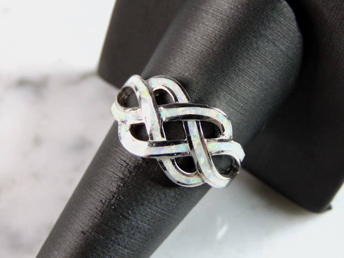 Womens Vintage Estate Sterling Silver Eternity Knot Opal Ring: A WOMENS VINTAGE ESTATE STERLING SILVER ETERNITY KNOT OPAL RING. THE RING IS A SIZE 10 AND WEIGHS 5g. FACE OF RING MEASURES 1/2" WIDE. THE RING MAKES A BEAUTIFUL GIFT FOR THAT SOMEONE SPECIAL. ANY OTH