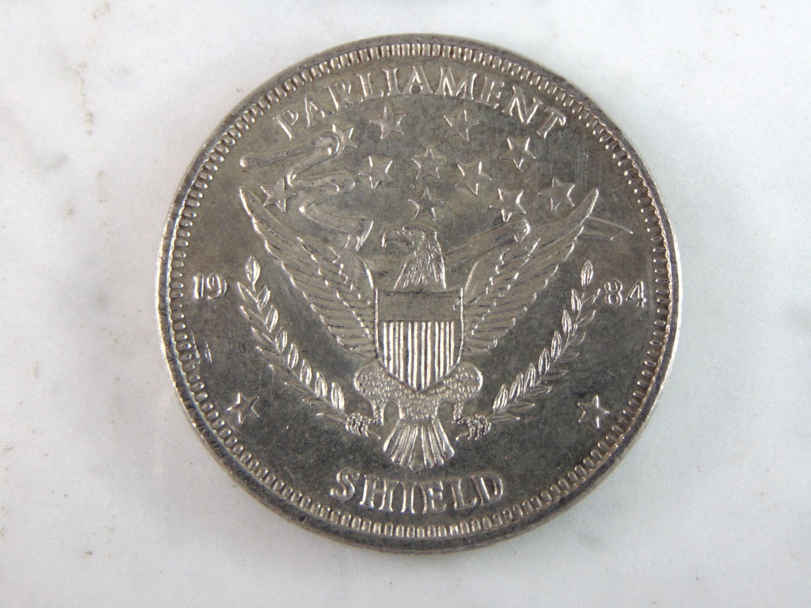 1984 Parliament Shield .999 Fine Silver Coin: FOR SALE IS THIS 1984 PARLIAMENT SHIELD .999 FINE SILVER COIN . COIN WEIGHS 1 TROY OUNCE. COIN APPEARS TO BE IN GOOD CONDITION, UNC, HOWEVER WE ARE NOT COIN EXPERTS WHEN IT COMES TO PROPER GRADING. FI