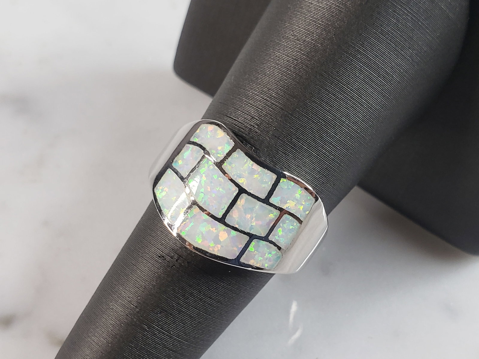 Womens Estate Sterling Silver Modernist Opal Ring: A WOMENS ESTATE STERLING SILVER MODERNIST OPAL COLORED RING. THE RING IS A SIZE 6.75 AND WEIGHS 4.3g. WIDTH OF RING MEASURES 1/2". NOT SURE IF STONE IS NATURAL OR MAN MADE. THE RING MAKES A BEAUTIFUL