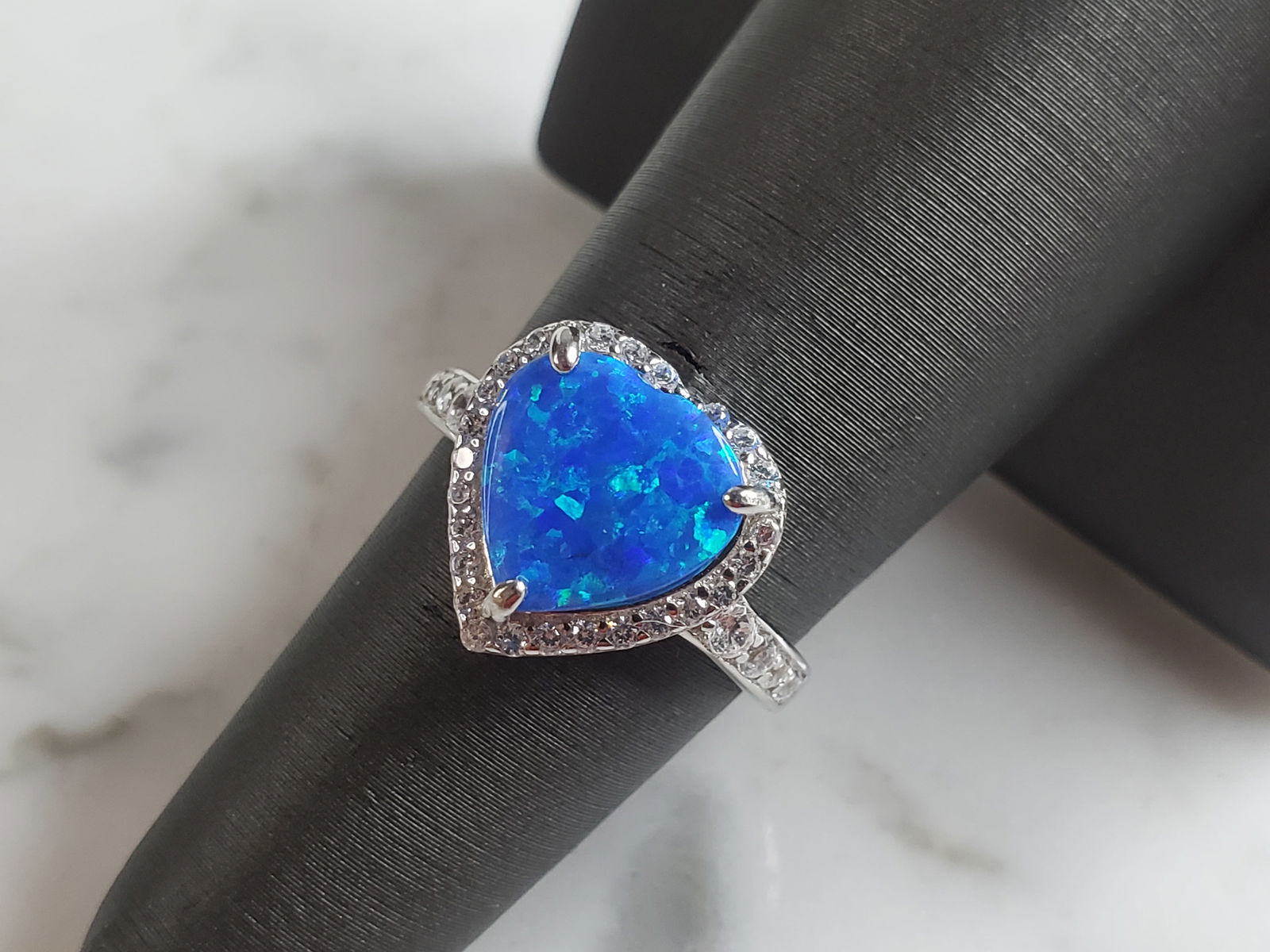 Womens Estate Sterling Silver Modernist Blue Opal Heart Ring: A WOMENS ESTATE STERLING SILVER MODERNIST BLUE OPAL COLORED RING. THE RING IS A SIZE 7.0 AND WEIGHS 3.2g. WIDTH OF RING MEASURES 1/2". NOT SURE IF STONE IS NATURAL OR MAN MADE. THE RING MAKES A BEAUTI