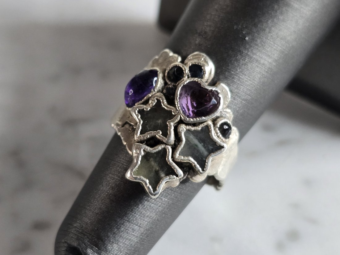 Womens Fine Silver Modernist Amethyst Multi Star Ring: A WOMENS FINE SILVER MODERNIST STAR RING WITH AMETHYST AND TOPAZ STONES. NOT SURE IF THE STONES ARE REAL OR MAN MADE. THE RING IS A SIZE 5.5 , AND WEIGHS 5.2g. THE LENGTH OF THE RING IS 7/8". RING IS 